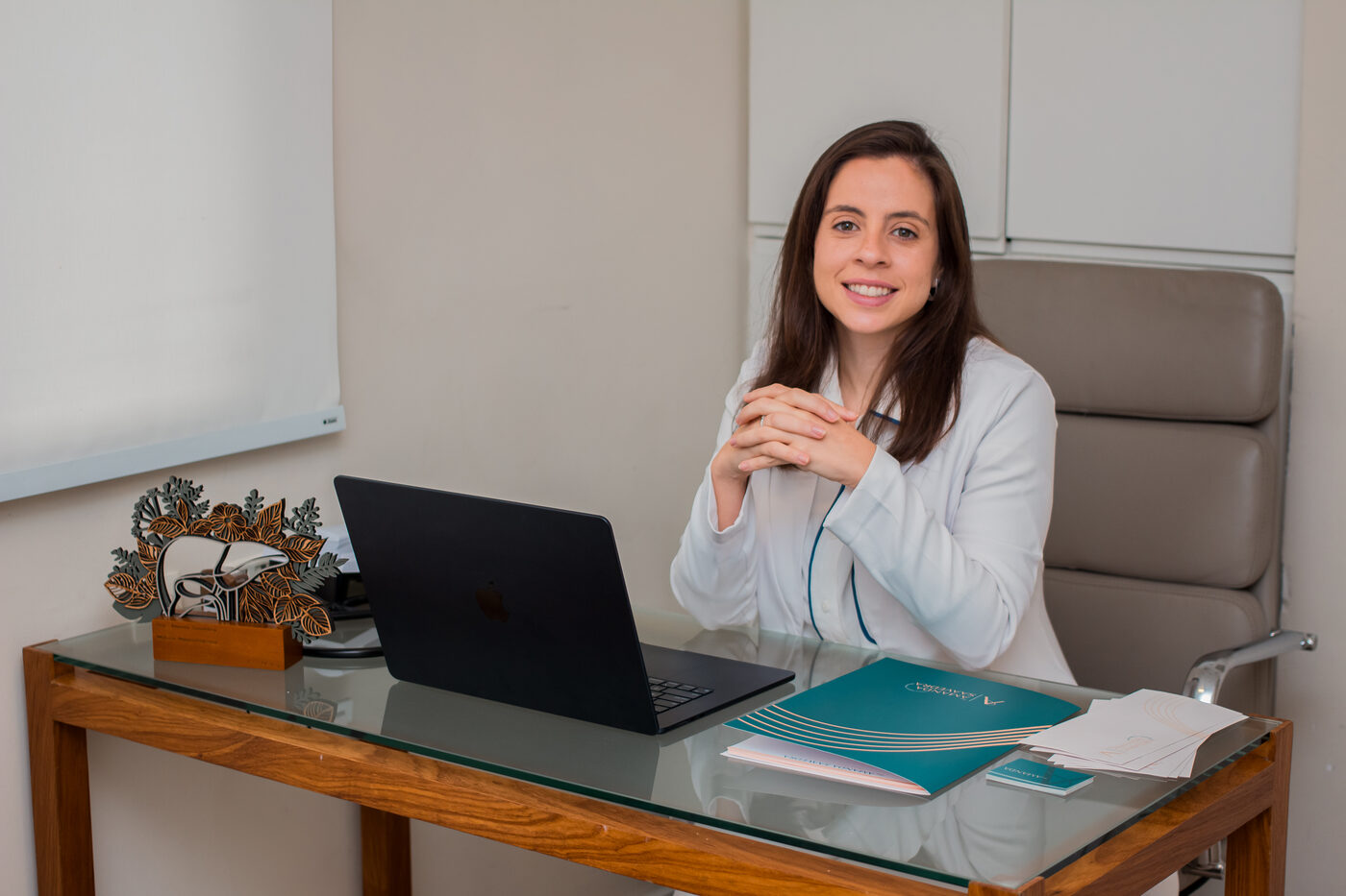Dra. Amanda Saavedra à mesa do consultório no Jardim Botânico, Rio de Janeiro